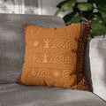 Square throw pillow with an ancient Trypillian pattern in terracotta and gold tones, featuring sun and figure motifs, resting on a gray sofa.