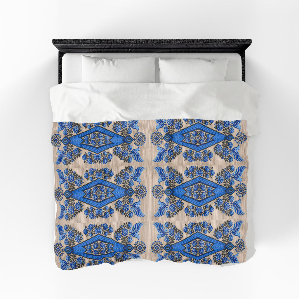 Ukrainian Berehynia blanket with blue black folk art geometric pattern on bed
