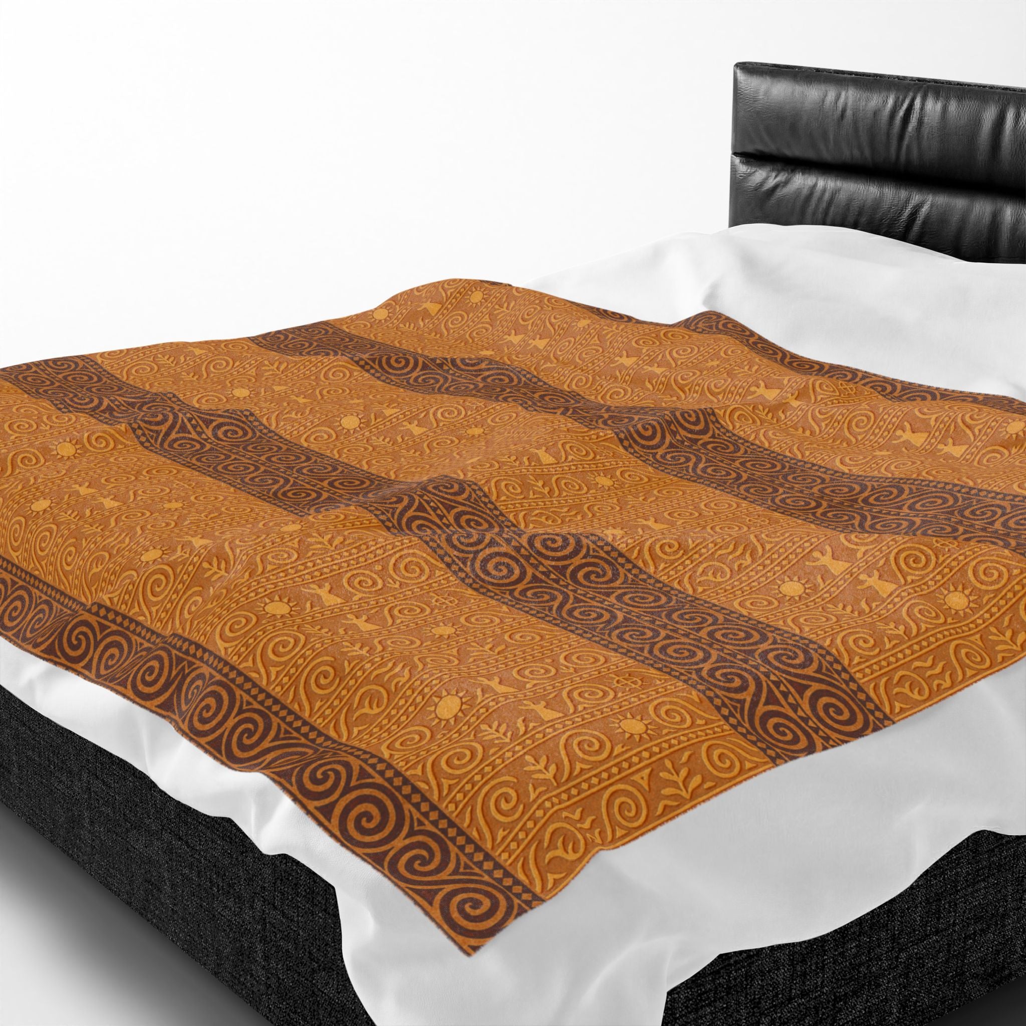 A velveteen plush blanket featuring rust-brown and ochre stripes with ancient Trypillian symbols, spread across a bed with white linens.