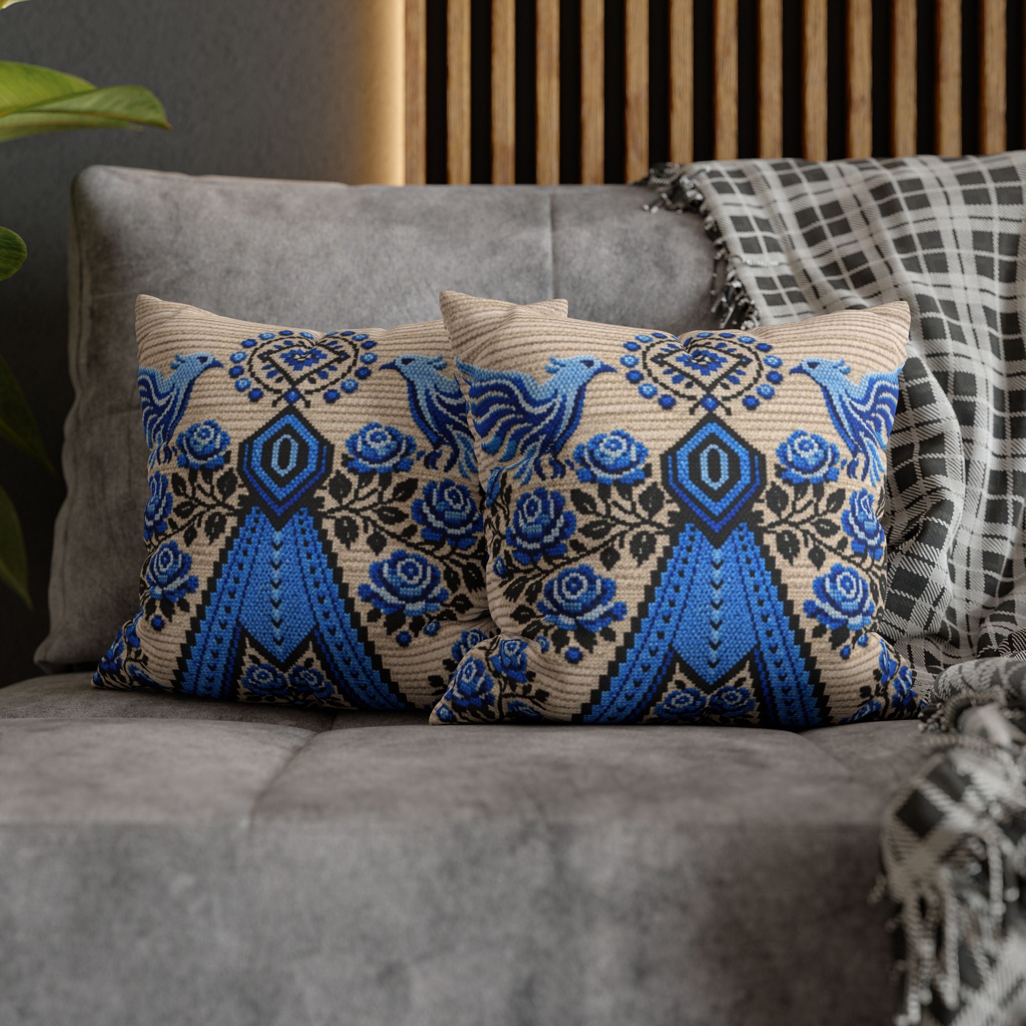 Ukrainian Berehynia throw pillow with blue black folk art pattern on sofa
