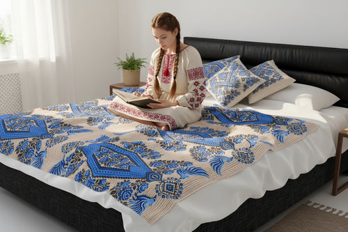 Ukrainian Berehynia blanket with blue black folk art geometric pattern on bed

