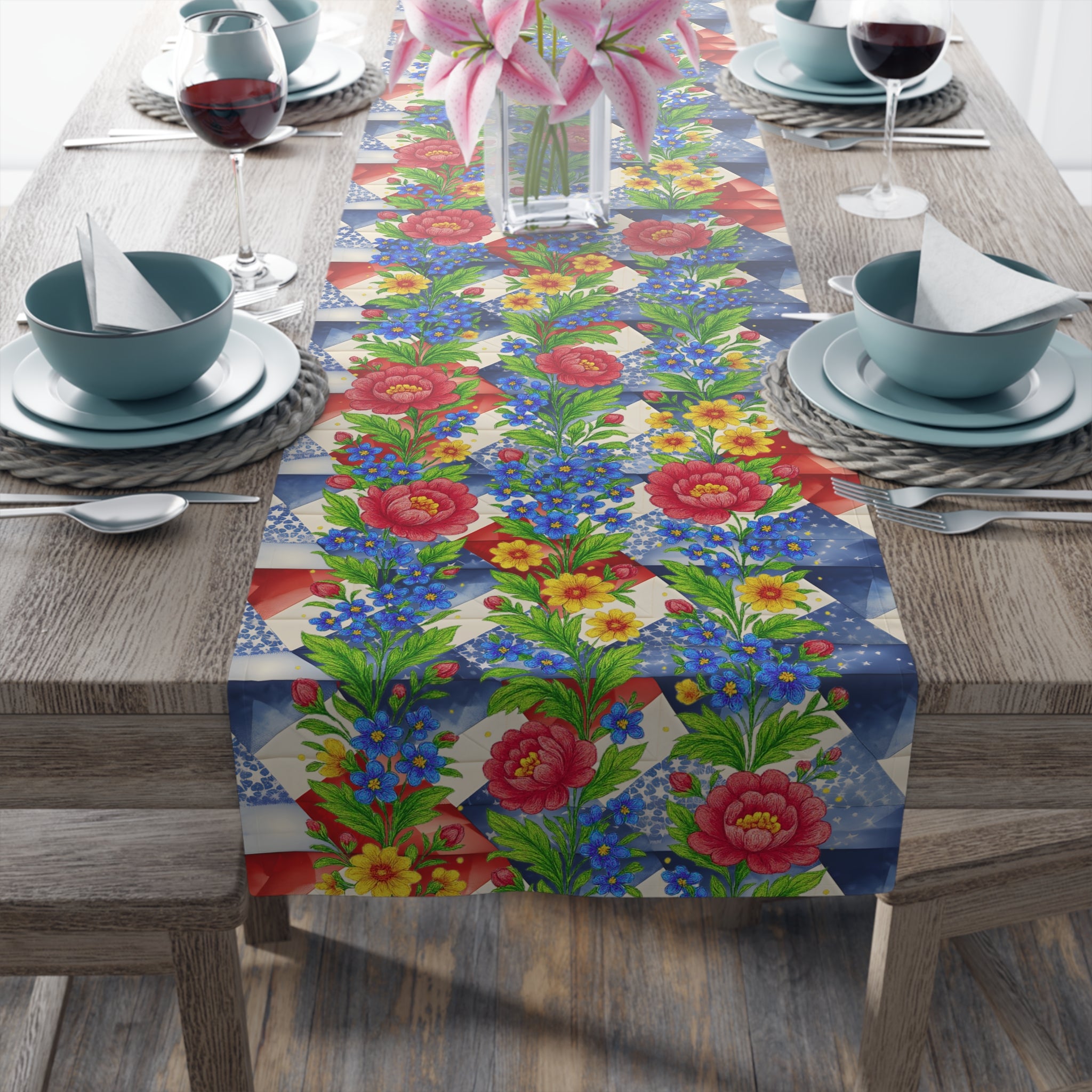 Floral table runner titled American Cozy, featuring red roses and blue wildflowers over a blue and white geometric pattern on a wooden dining table.