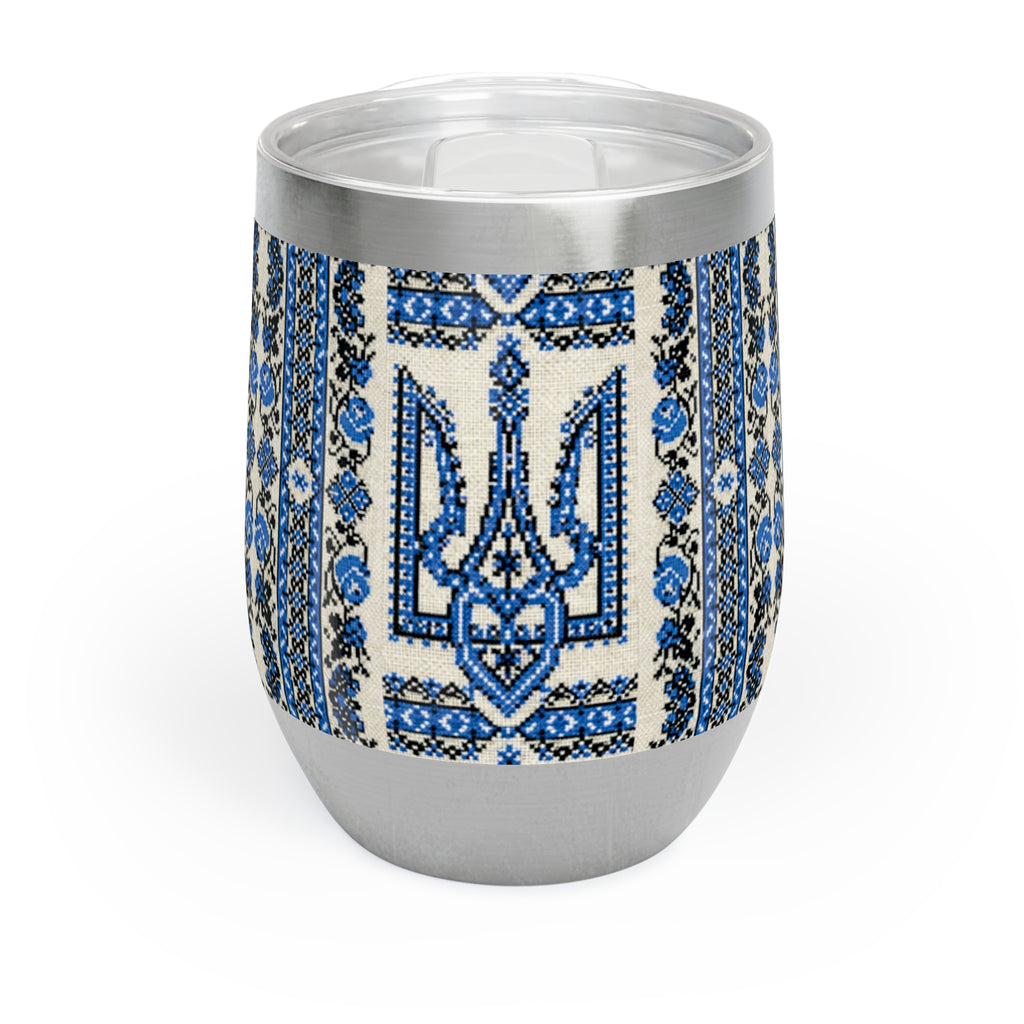 A 12oz stainless steel stemless wine tumbler with a white finish. The middle section is wrapped in a vibrant blue and black Ukrainian Trident (Tryzub) pattern with traditional folk floral embroidery details. It has a clear plastic lid with a slide opening.