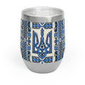 A 12oz stainless steel stemless wine tumbler with a white finish. The middle section is wrapped in a vibrant blue and black Ukrainian Trident (Tryzub) pattern with traditional folk floral embroidery details. It has a clear plastic lid with a slide opening.